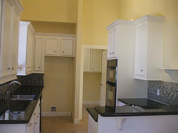 Kitchen area 11x9 note open door to utility room  housing multitude of cabinets for storage.  Room size is approx.