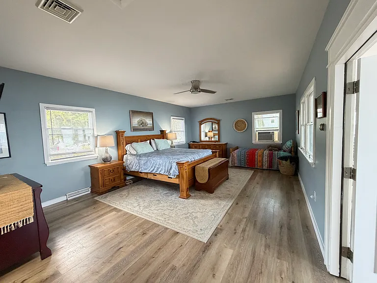 Spacious master bedroom with views of bay and sunrise from bed