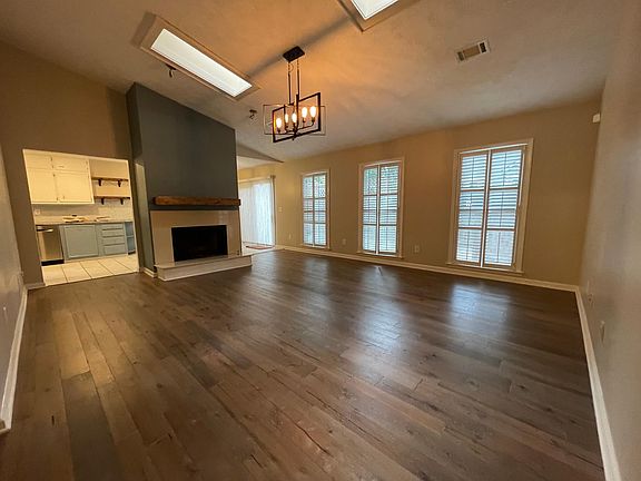 Spacious Living Room with new hardwood flooring, skylights, gas and gas fireplace.