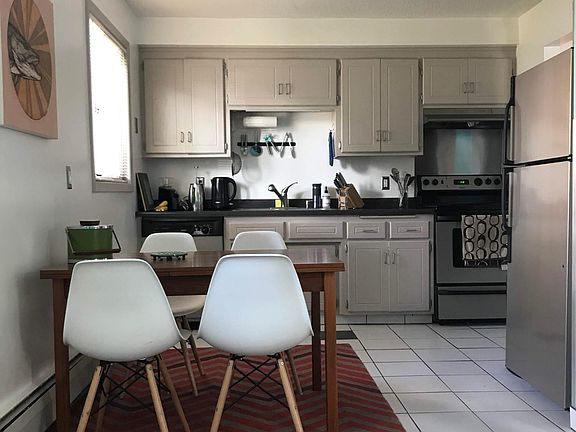 Kitchen with stainless steel appliances, opens to dining area and living area.