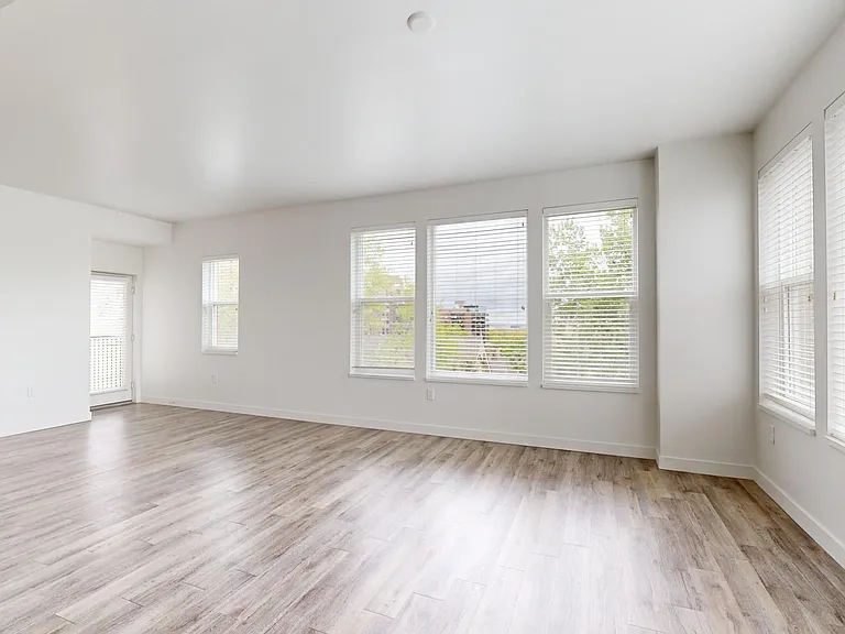 Apartment dining and living room with wood-style flooring.