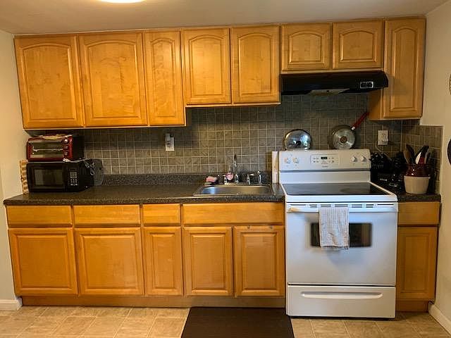 Kitchen with smooth top range and refrigerator