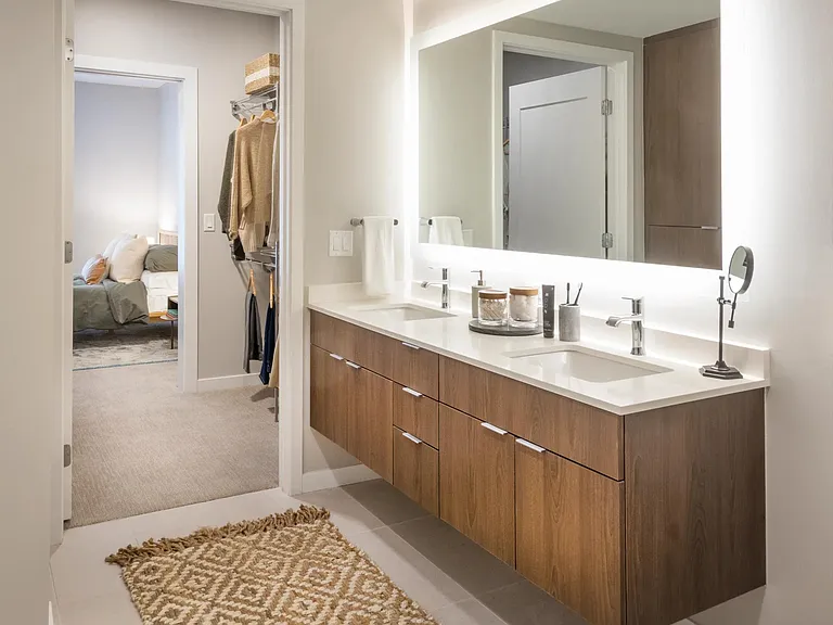 Ultra modern bathroom with floating vanities and pass-through closet.
