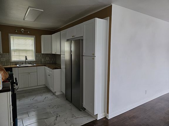 Newly redesigned Kitchen with stove, microwave, refrigerator, dishwasher, and garbage disposal