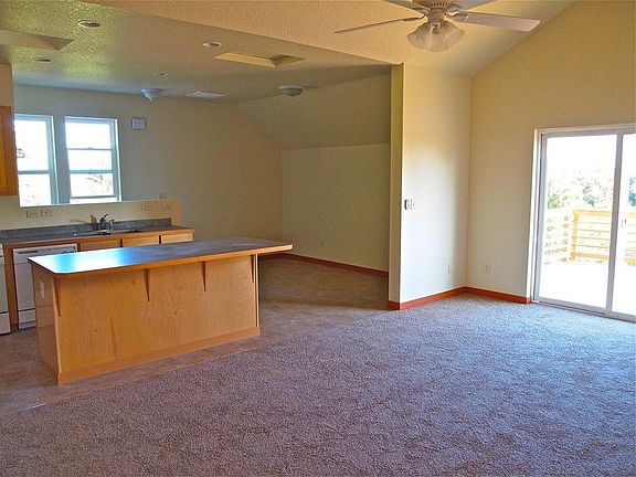 Sliding door access to deck off of Grand Room, which includes island bar, kitchen and living room.