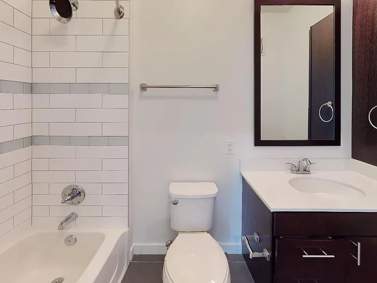 Apartment bathroom with tile flooring.