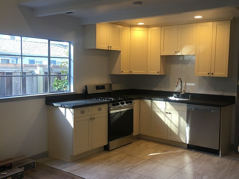 kitchen featuring new stainless steel appliances high end cabinets and grey quartz counter top