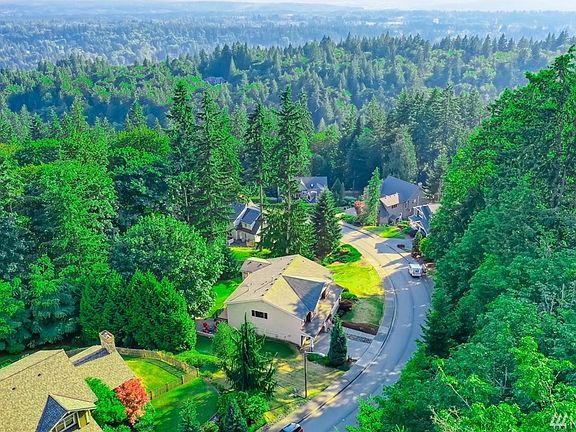The house is centered in this photo, and it was taken to show the wooded park land across the street from the front of the house, maintaining the private setting of the home. 