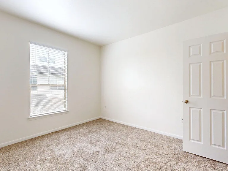 Spacious apartment bedroom with carpet floor.