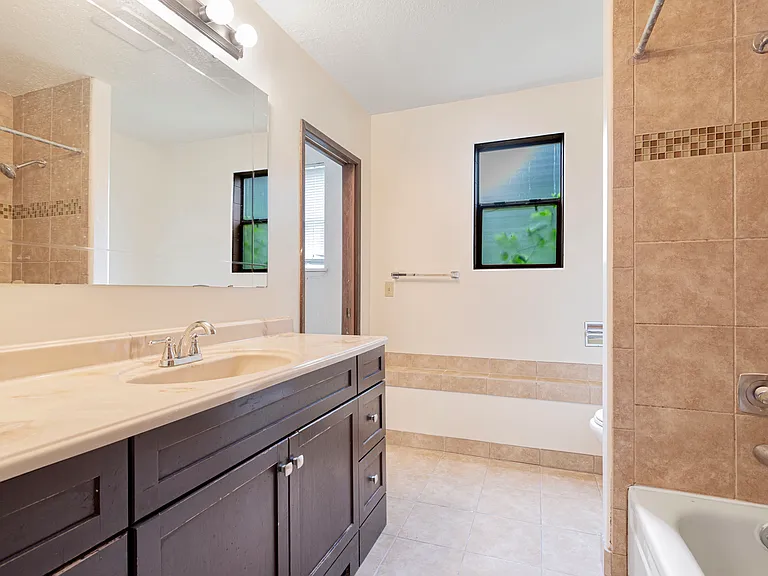 Unit 2 bathroom with double sinks and bathtub
