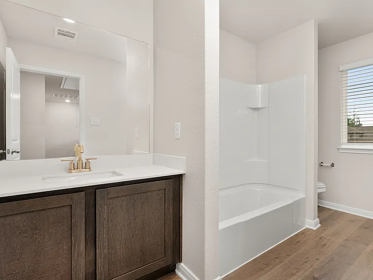 The secondary bathroom has a sprawling vanity and shower-tub combo.