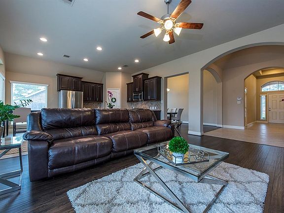 The front door leads you into a grand tiled entryway with 14 ft ceilings and the open concept living, dining, kitchen, and breakfast area. Beautiful wood-like floors grace the living room and dining room.