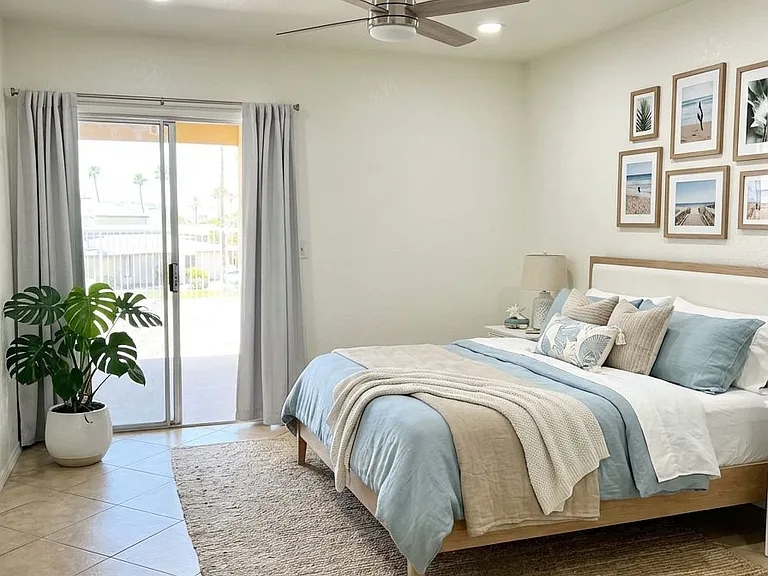 Virtually Staged Primary Bedroom With Sliding Door Leading Out to the Back Yard and Laundry Area.