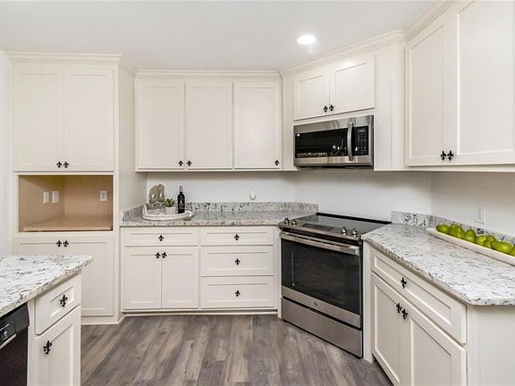Gorgeous kitchen with white cabinets, granite countertops, and stainless appliances. 