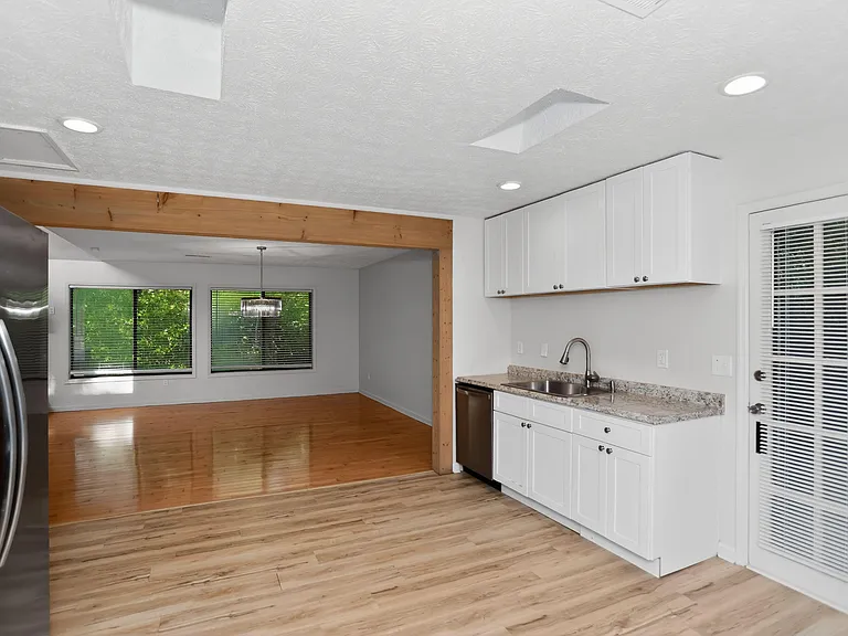 Updated kitchen with generous cabinet storage, granite-look counters, and an open layout flowing to the dining area.