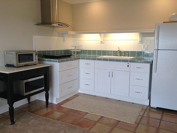 Light and bright, counters are a crackled glass tile. Marble top Island on wheels.