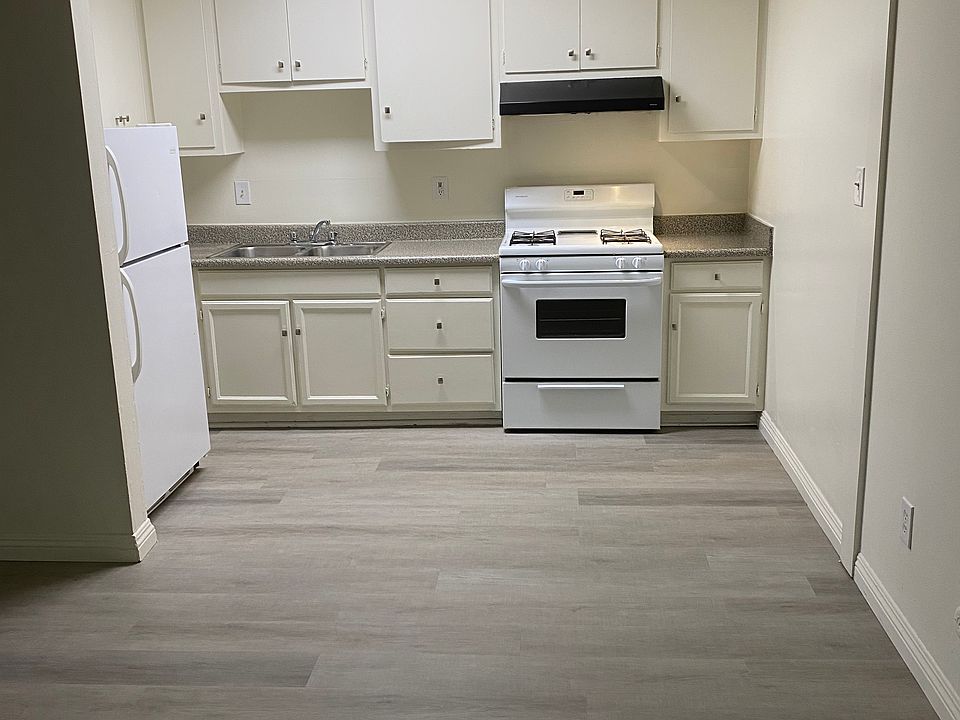 Large open kitchen with gas range and a refrigerator.