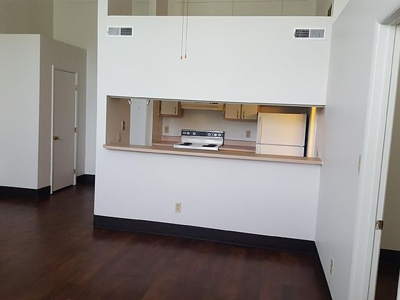 view of kitchen from living room- door on left side is a coat closet