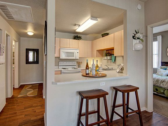 A kitchen with light cabinets and white appliances