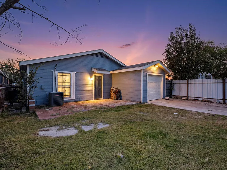 View of front of house with concrete driveway, a garage, and a patio area