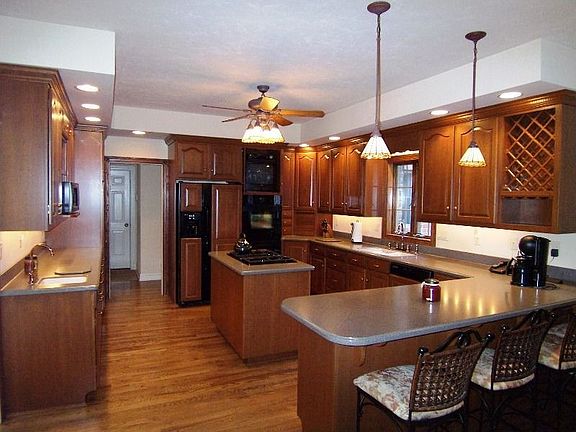 Huge cherry kitchen features ample storage & informal dining areas