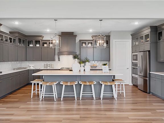 Kitchen with island, pendant lighting and glass-front upper cabinets