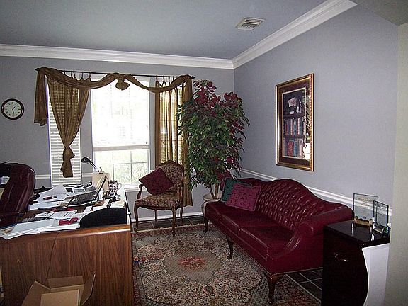Versatile study or formal living off entry complete with crown and chair railing.