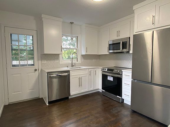 Kitchen with back door leading to garage, backyard and back deck.