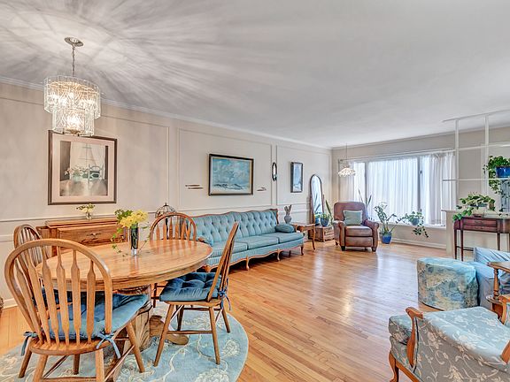 The front door on the right is protected with a decorative half wall "bookshelf' unit. A large picture window looks out to the front.