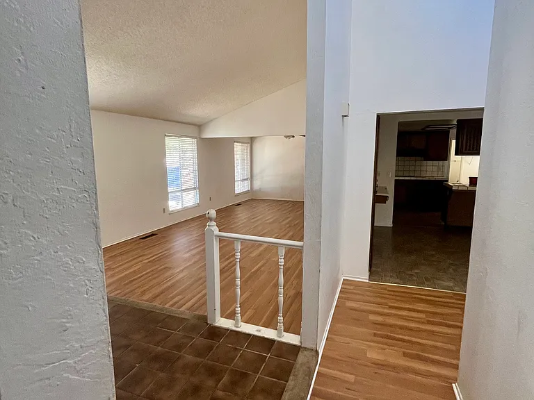 Entrance, hallway, living and dining rooms, and kitchen in the background.