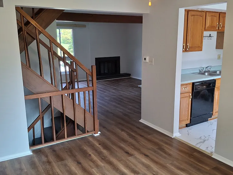 View from Dining Room to Kitchen, Stairs and Living Room with Fireplace.