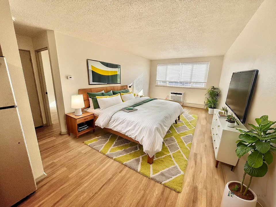 Experience luxury and comfort in this stylish bedroom with vibrant decor and natural light.