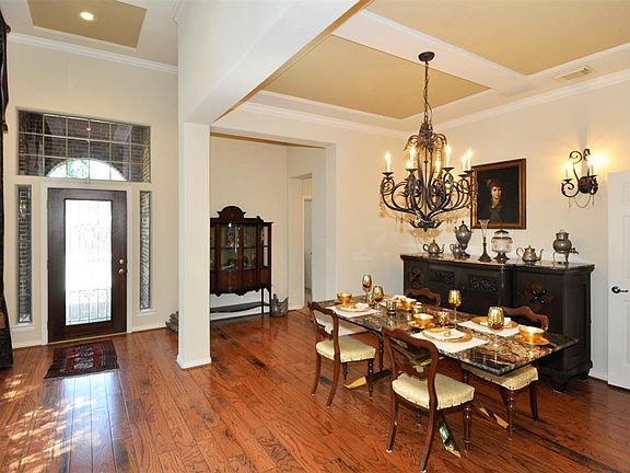 Elegant foyer with wide plank distressed wood flooring flows into the formal dining room and study areas. View of formal dining room with upgraded lighting.