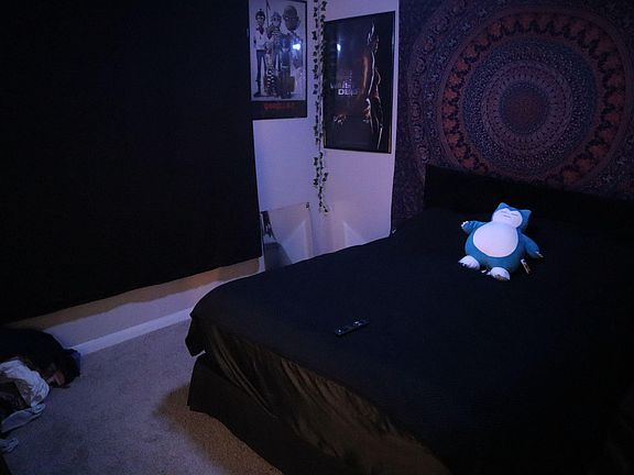 Bedroom with a full-size bed, soft carpeting, and window coverage for added privacy and light control.