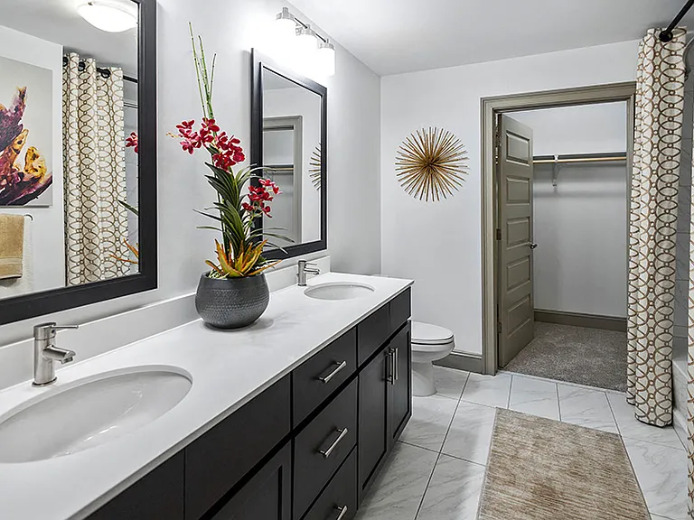 Bathrooms with Carrara-style tile, soaking tubs and showers with frameless glass doors