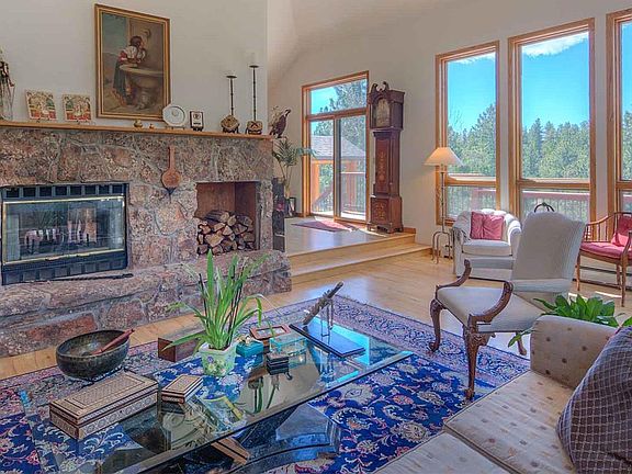 Living Room features a moss rock fireplace & mountain views!
