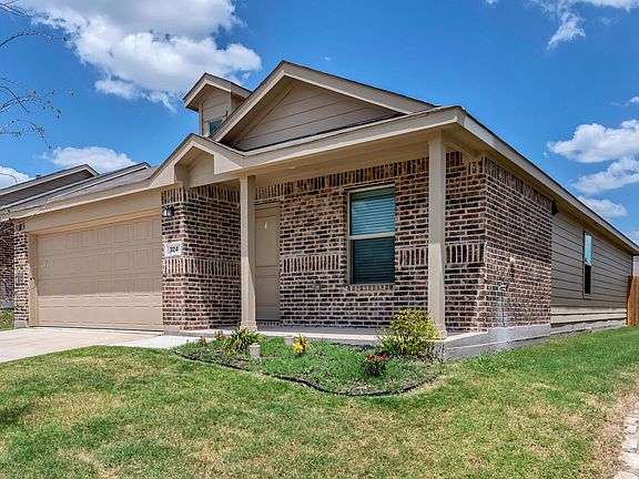 View of front of house featuring brick siding, a front yard, concrete driveway, and an attached garage