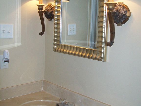 Hall bath features new lighting, mirror, ceramic tile floor