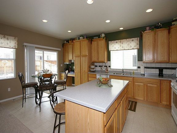 Kitchen has Corian counters, 42 inch cabinets, island, can lighting