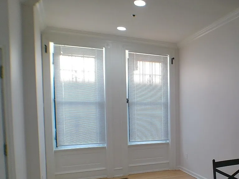 Open area with tall windows and blinds, recessed lighting, and wood-style flooringideal for a dining nook or flex space.