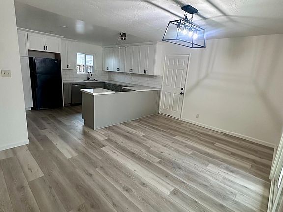 front door towards dining room, door to garage and kitchen (fridge being replaced and stove / hood being installed)