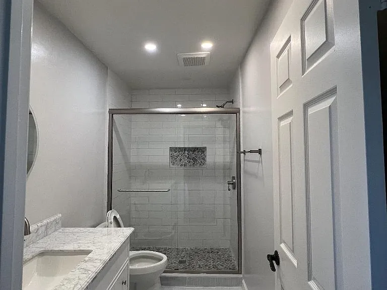 Newly remodeled bath with new tile, vanity, toilet, and floors