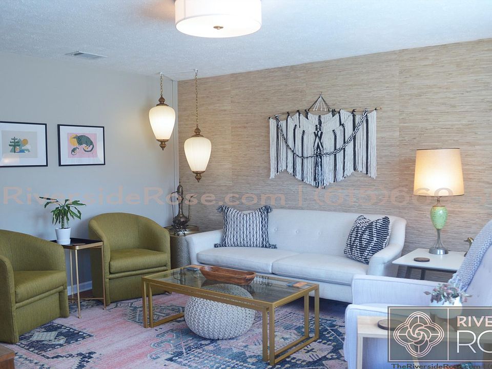 Living room with mid-century boho decor, local art, and high-end furnishings.