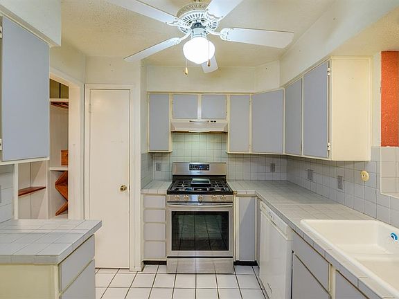 Kitchen with stainless steel gas stove and walk-in pantry.