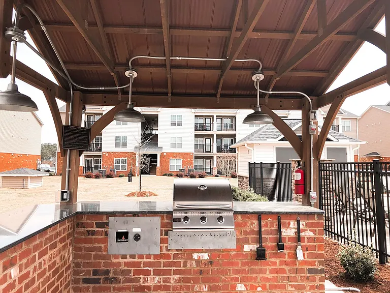 There is a community grill station and outdoor dining space conveniently located at the center of the property near the pool, perfect for summer days.