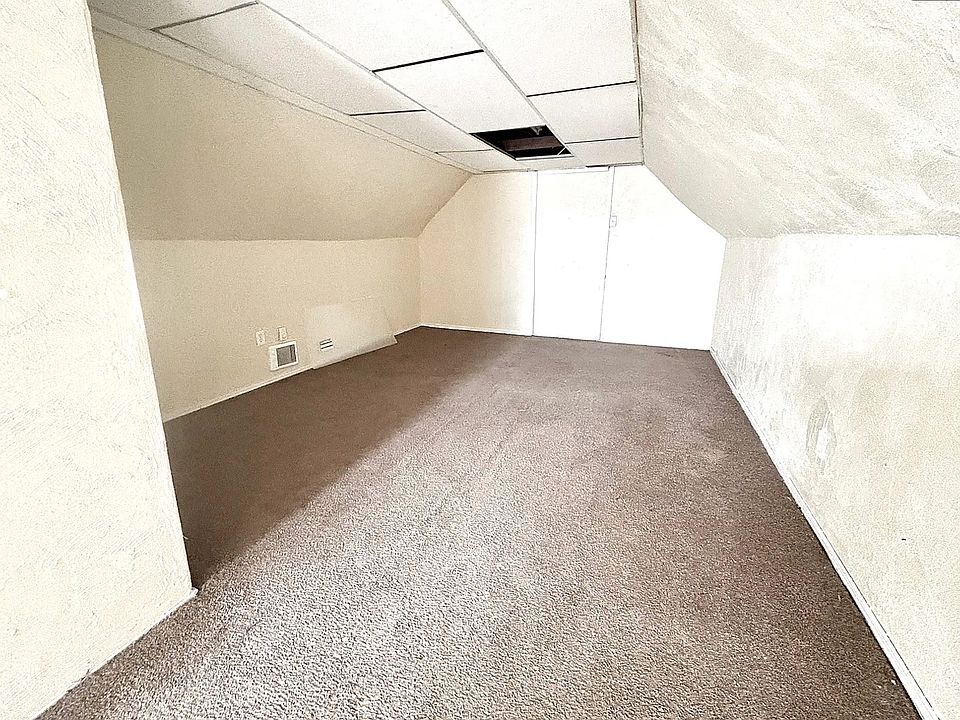 Bonus bedroom with vaulted ceiling and carpet