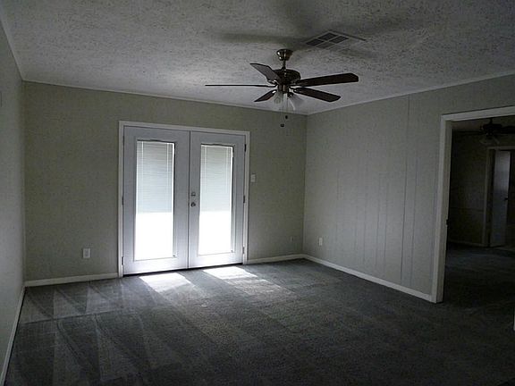 Living Area with ceiling fan, new paint carpet and new energy efficient patio doors