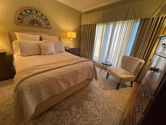 Primary bedroom with queen bed, TV and balcony..