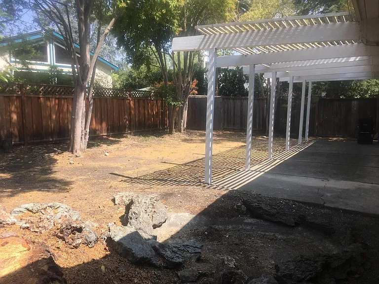large backyard surrounded by trees
