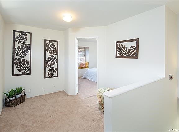 Walk up the stairs and a secondary living nook is discreetly arranged. This area would work well as a den, TV area, sitting area